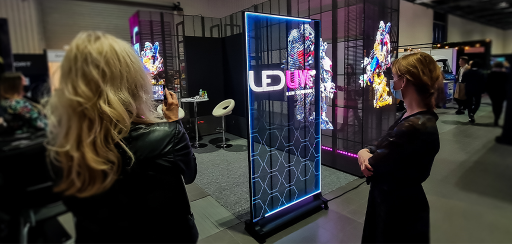 Two womens waching transparent led boards on ledlive booth