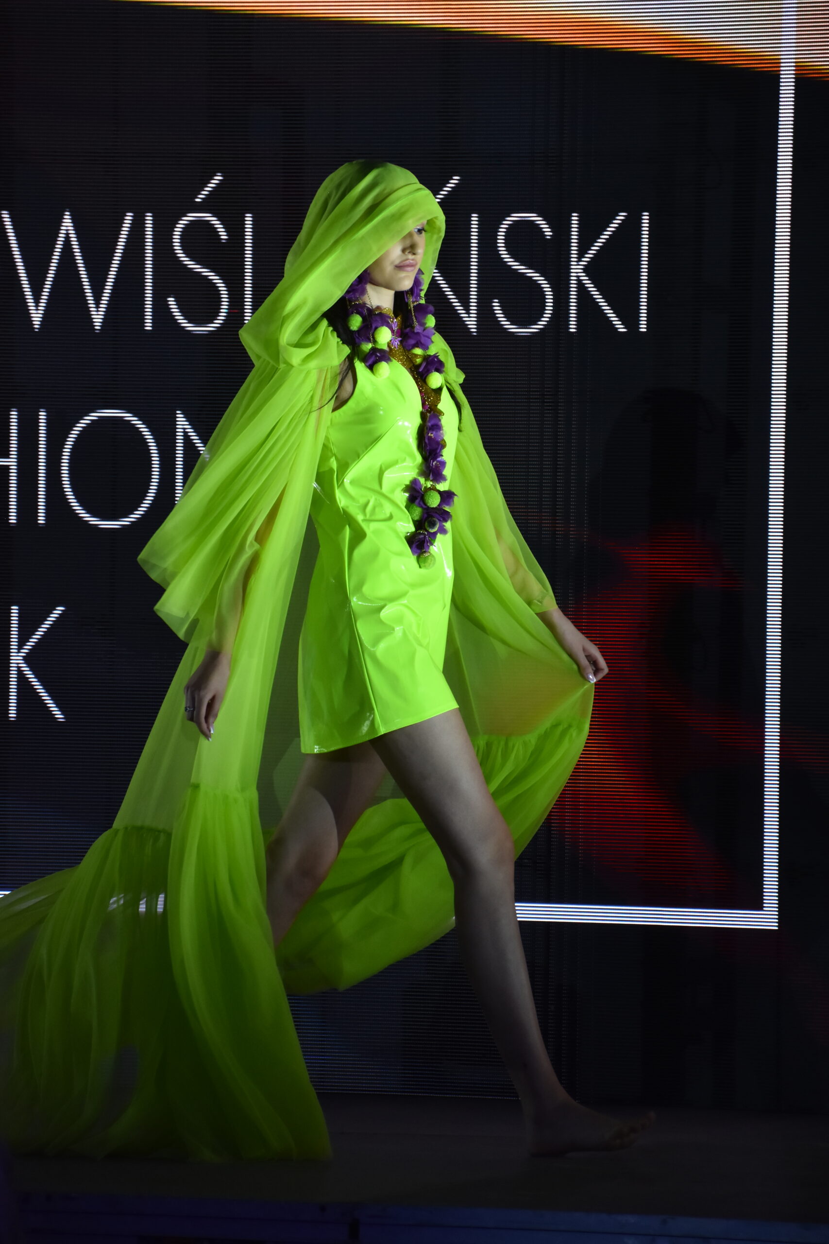Modelka na tle transparnentnego ekranu LED w trakcie Nadwiślańskiego Fashion Week
