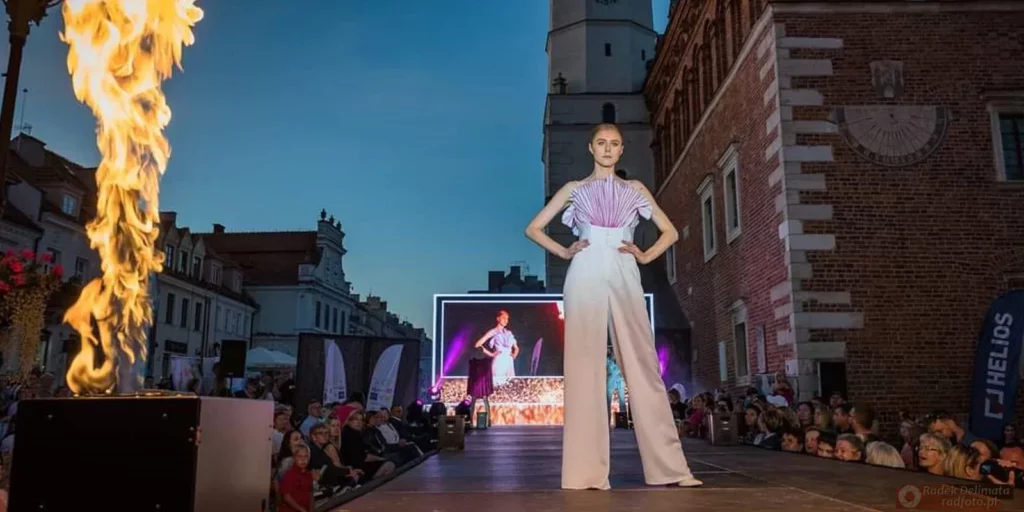 Modelka na tle ekranu LED przy słupie ognia w trakcie Nadiwślański Fashion Week